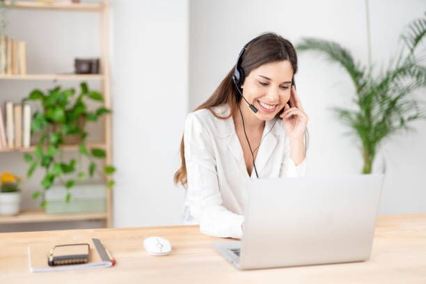 A woman wearing a headset is sitting in front of a laptop computer. - Plymouth, MN - Legacy Pro