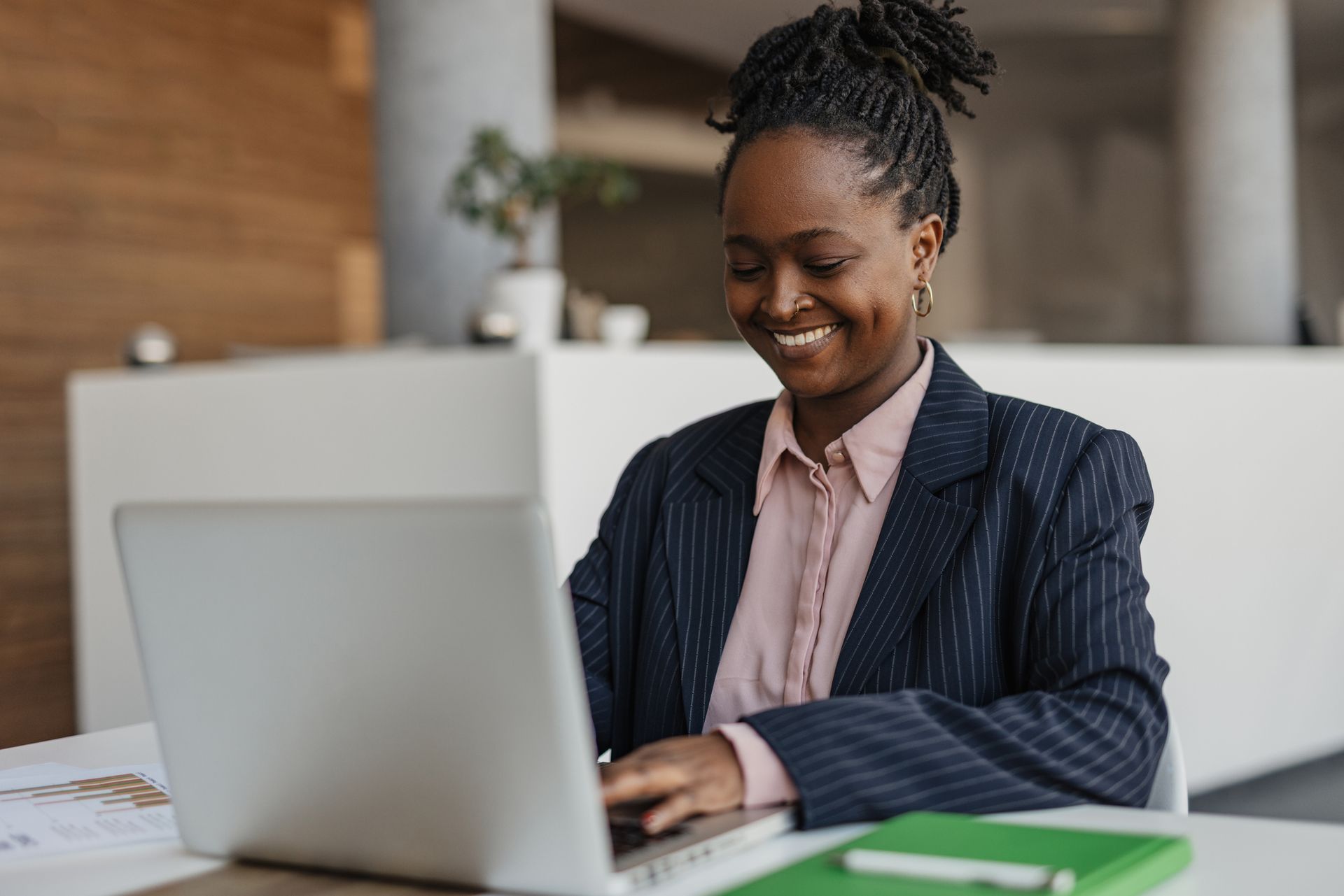 A woman is sitting at a desk using a laptop computer. - Plymouth, MN - Legacy Pro
