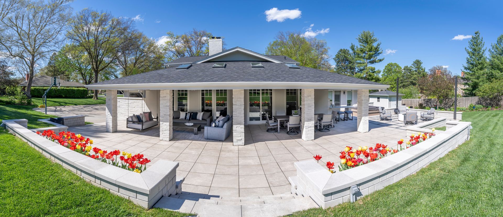 Patio pavilion with white columns and flower beds in a sunny park