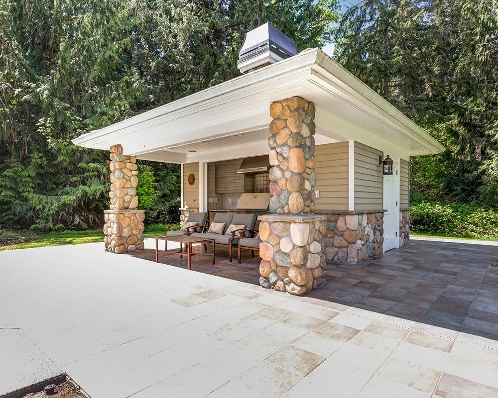 Chic outdoor kitchen space with stone columns and tile flooring | Lincoln, NE 