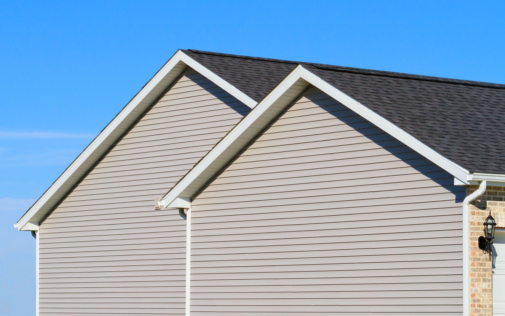 The roof of a house with a blue sky in the background.
