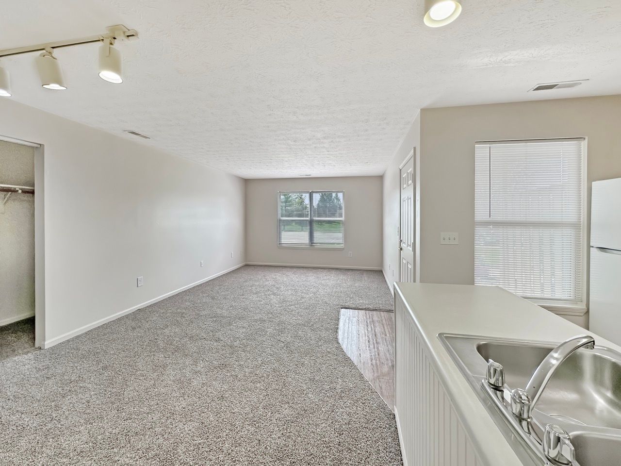 An empty apartment with a kitchen and a sink