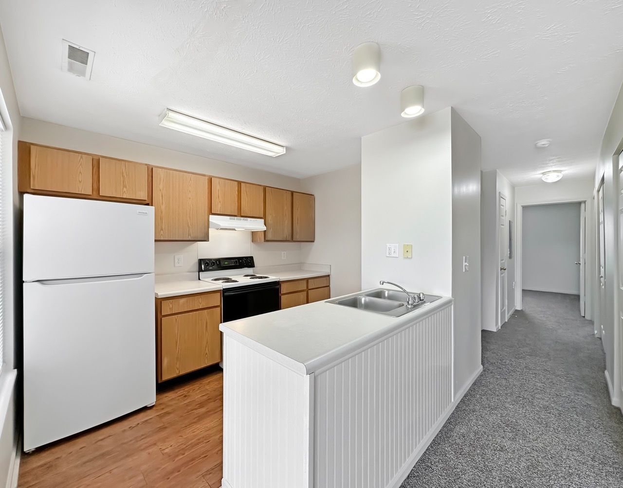 A kitchen with wooden cabinets and a white refrigerator