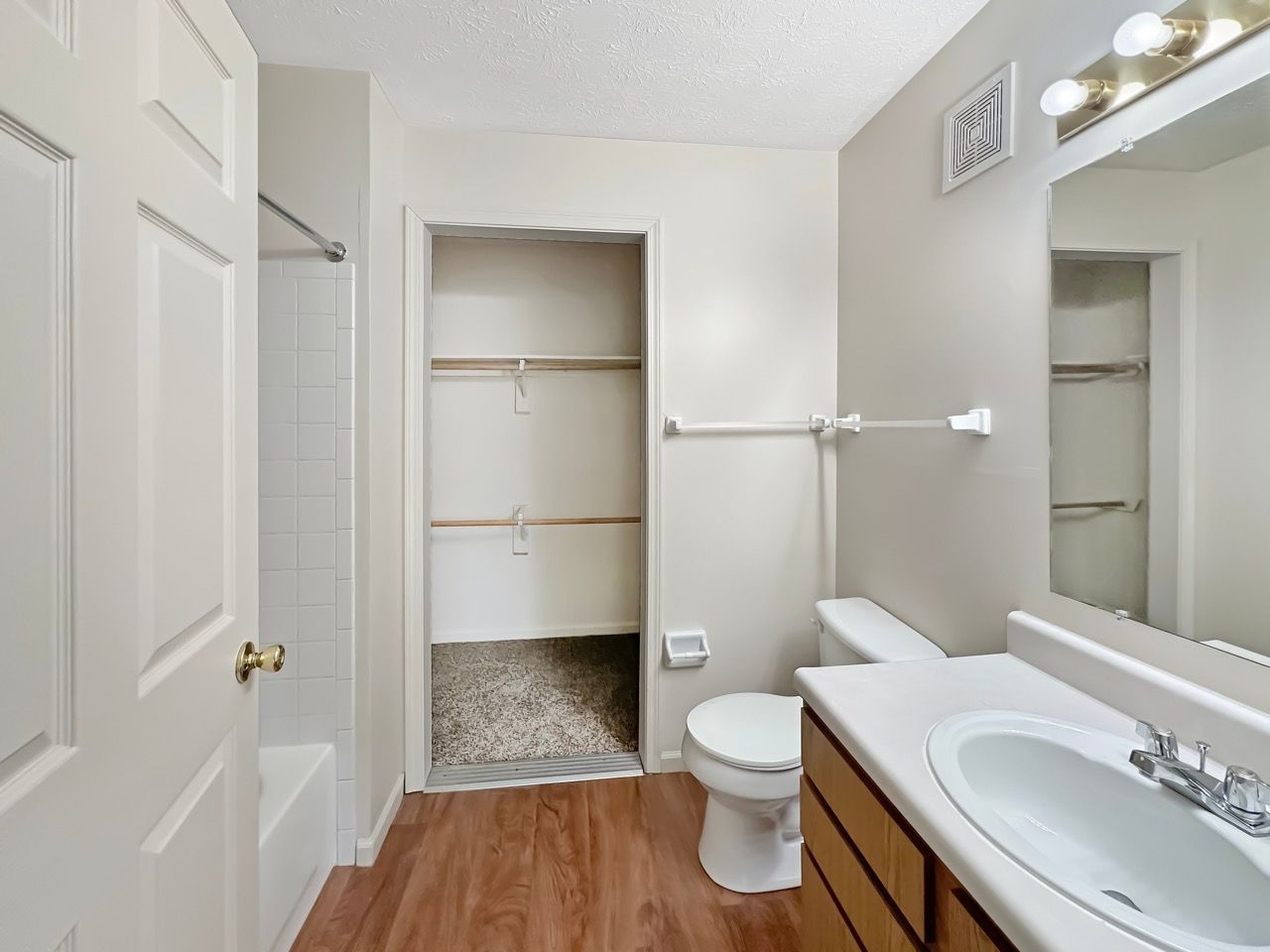 A bathroom with a toilet , sink and mirror