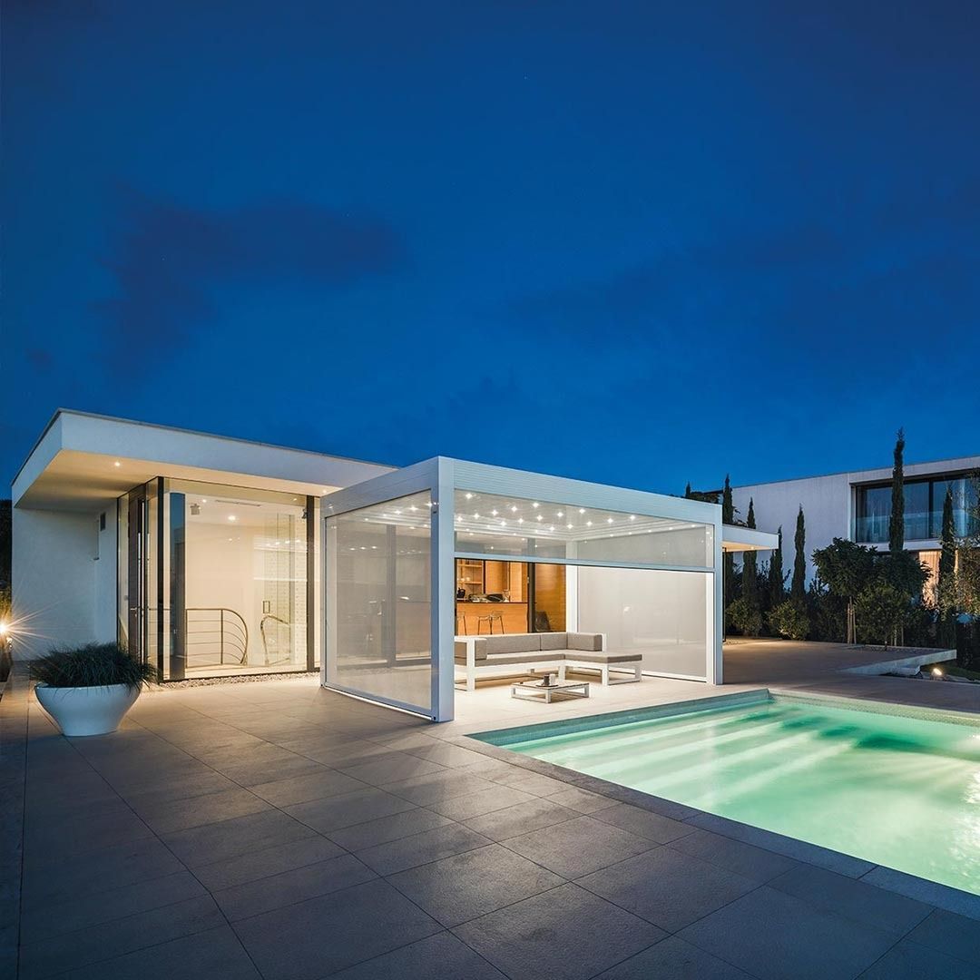 Casa moderna di lusso con patio illuminato e piscina al tramonto