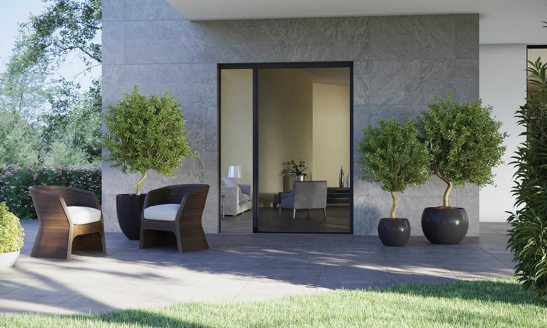 Patio moderno con due sedie in vimini, piante in vaso e una porta a vetri su una facciata di casa bianca.