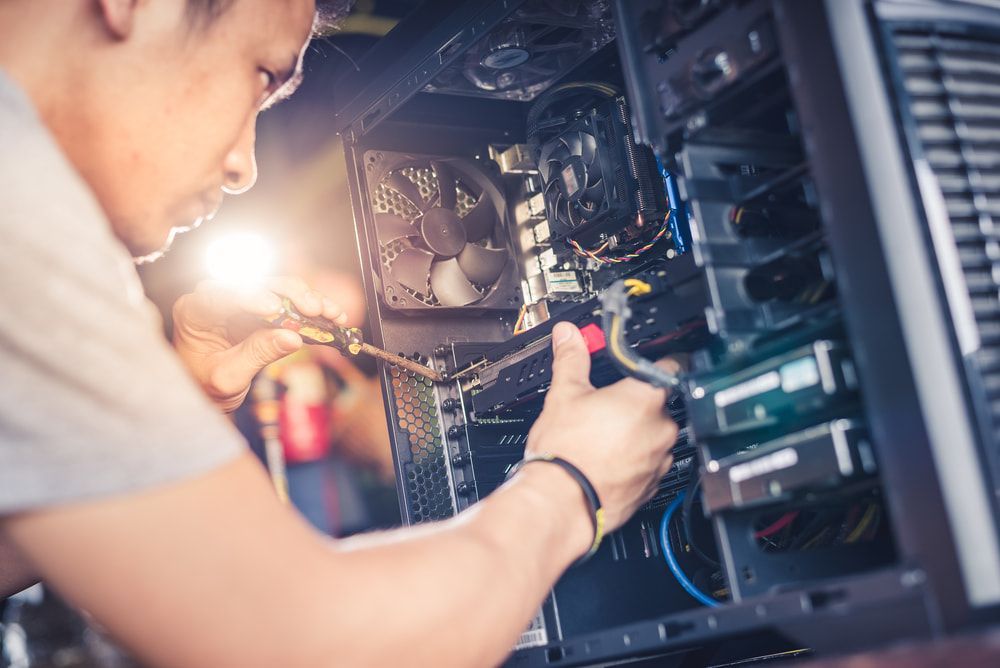 A Man Is Fixing A Computer With A Screwdriver — Black Label I.T. in Garbutt, QLD