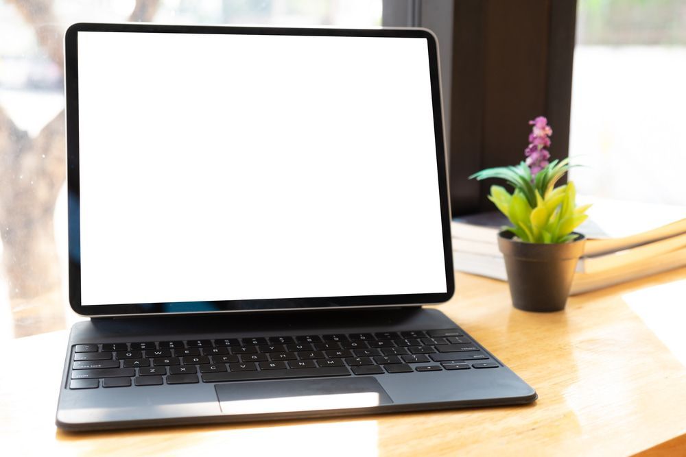 A Laptop Computer With A White Screen Is Sitting On A Wooden Desk — Black Label I.T. in Garbutt, QLD