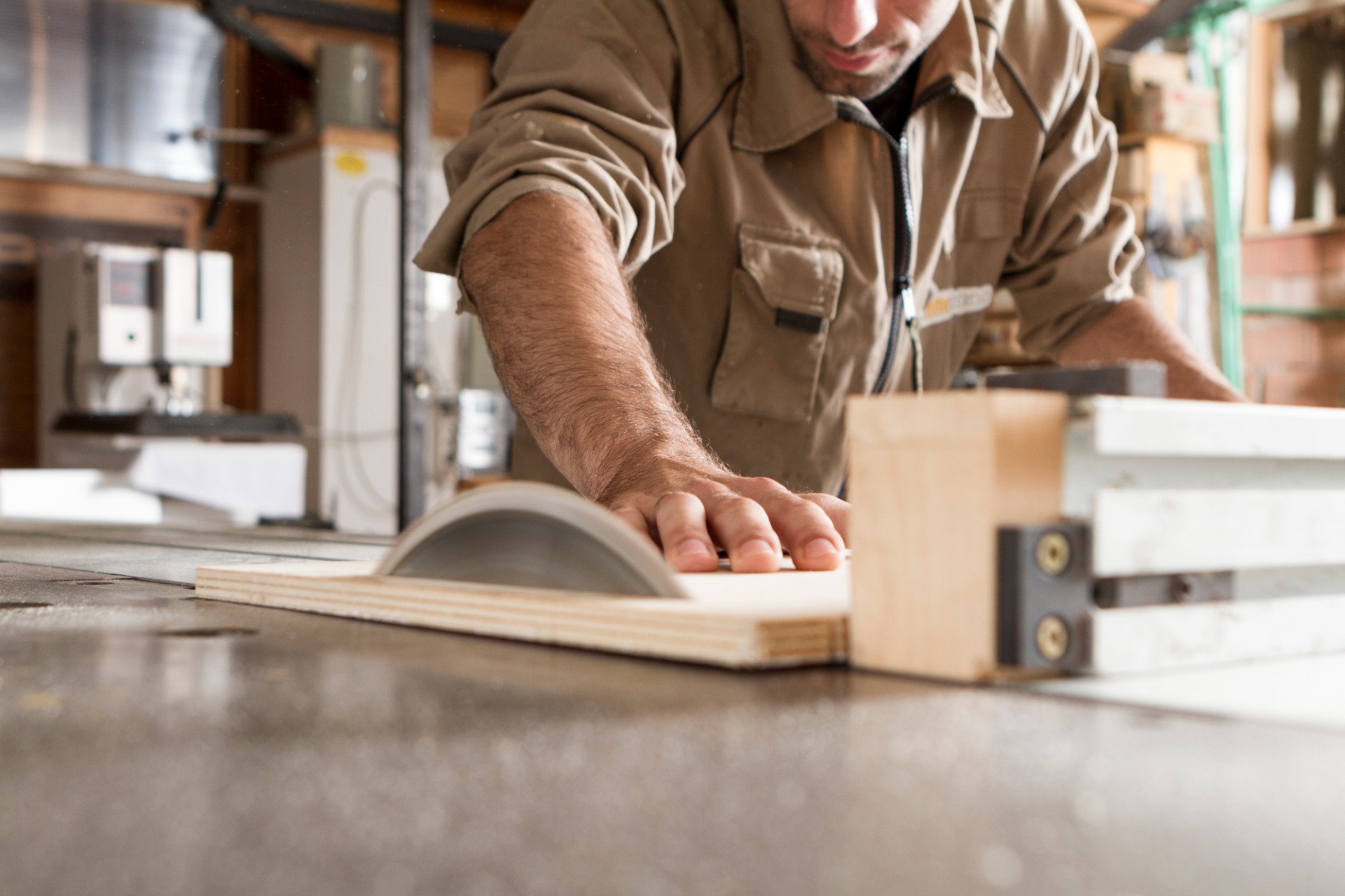 a joiner sawing a panel of wood