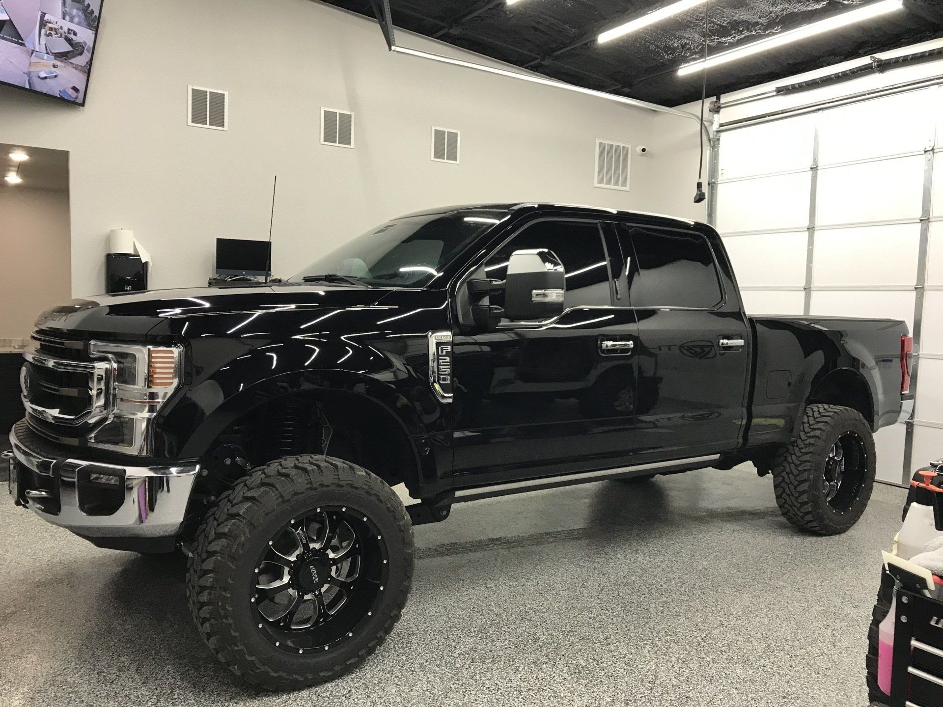 A black pickup truck is parked in a garage.