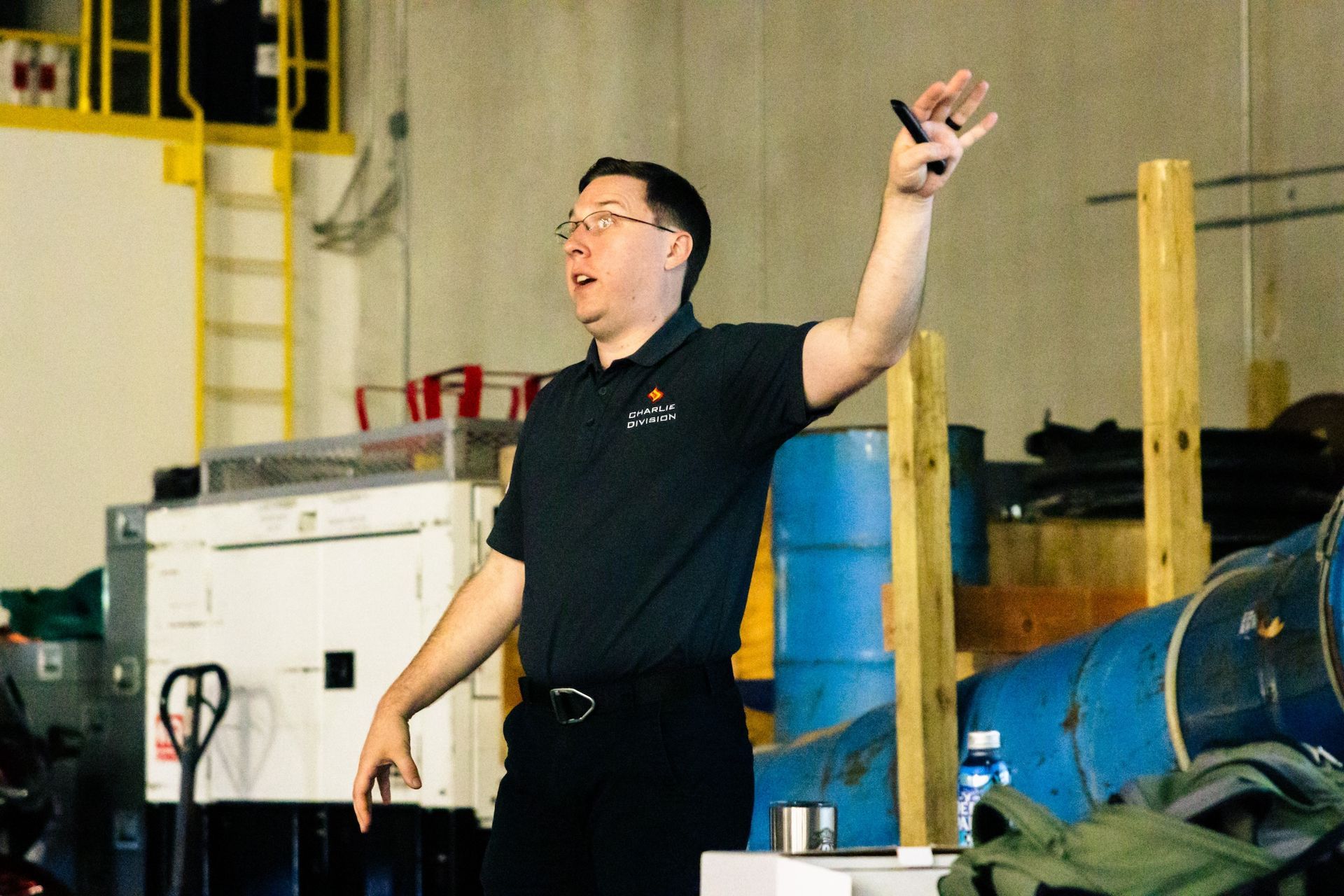 Portrait of man in glasses speaking with his left hand outstretched