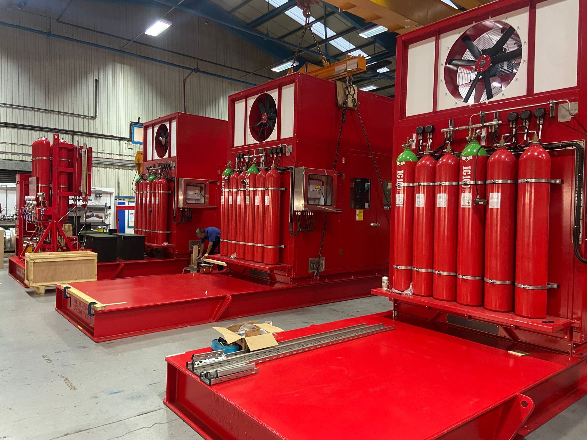 A warehouse filled with lots of red cylinders and fans.