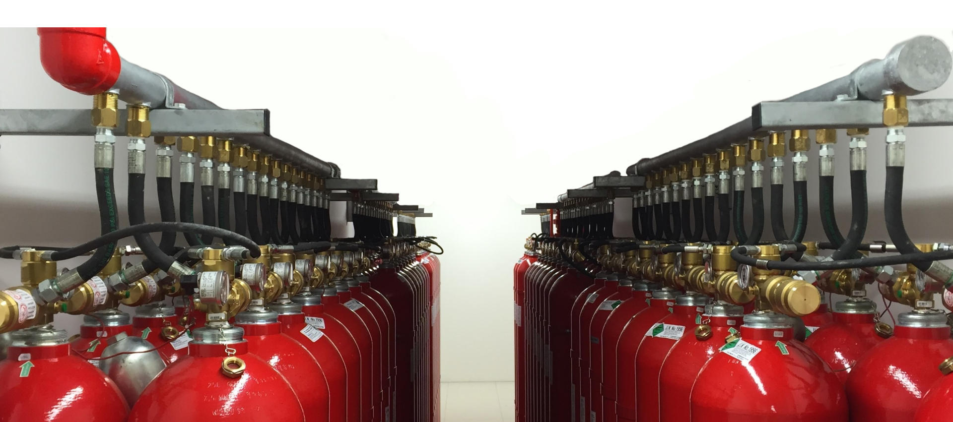 A row of red fire extinguishers are lined up in a room.