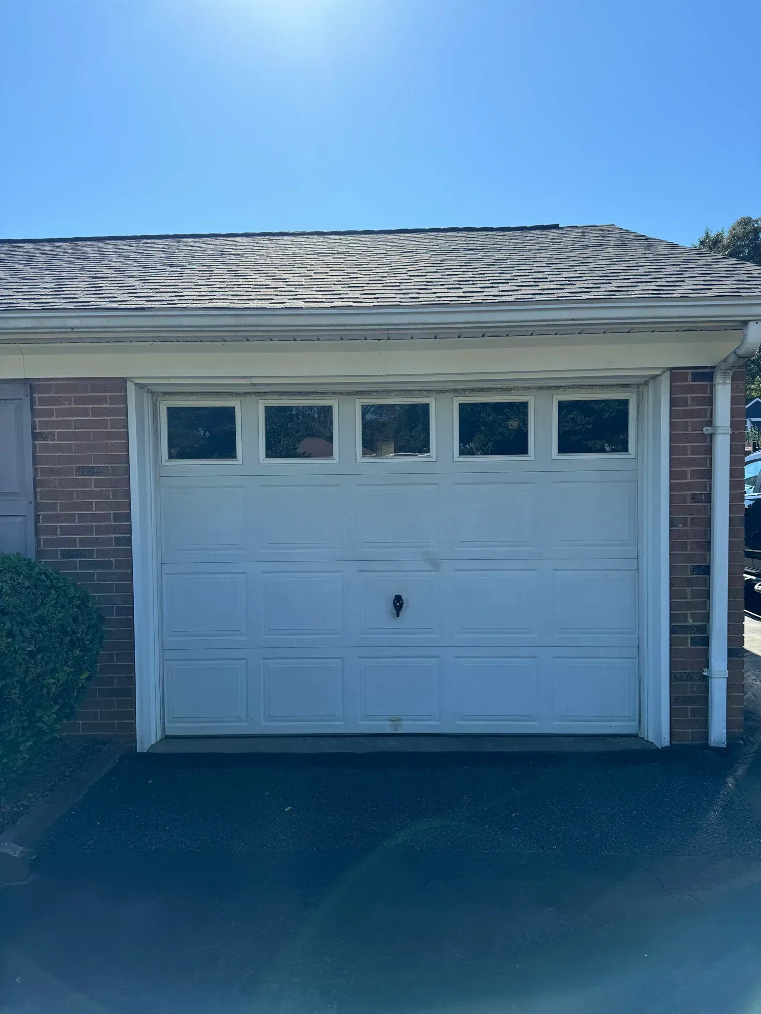 White garage door on a house exterior under a blue sky