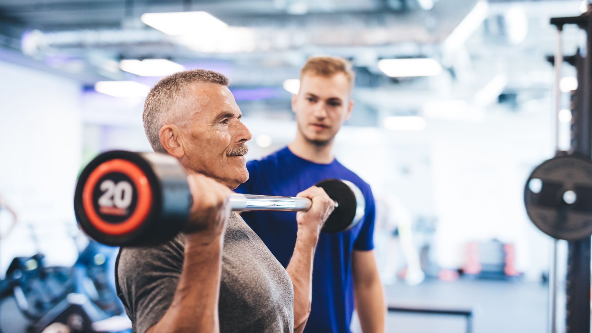 A man is lifting a barbell with the number 20 on it representing men's health