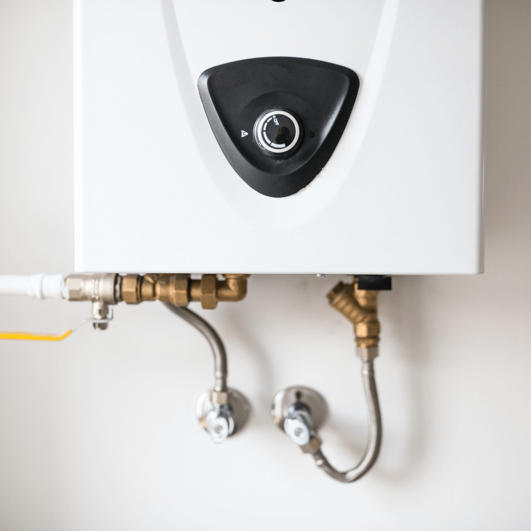 A white water heater with brass pipes attached to it
