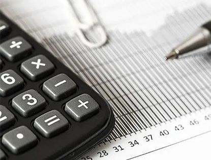 A calculator is sitting on top of a graph next to a pen.