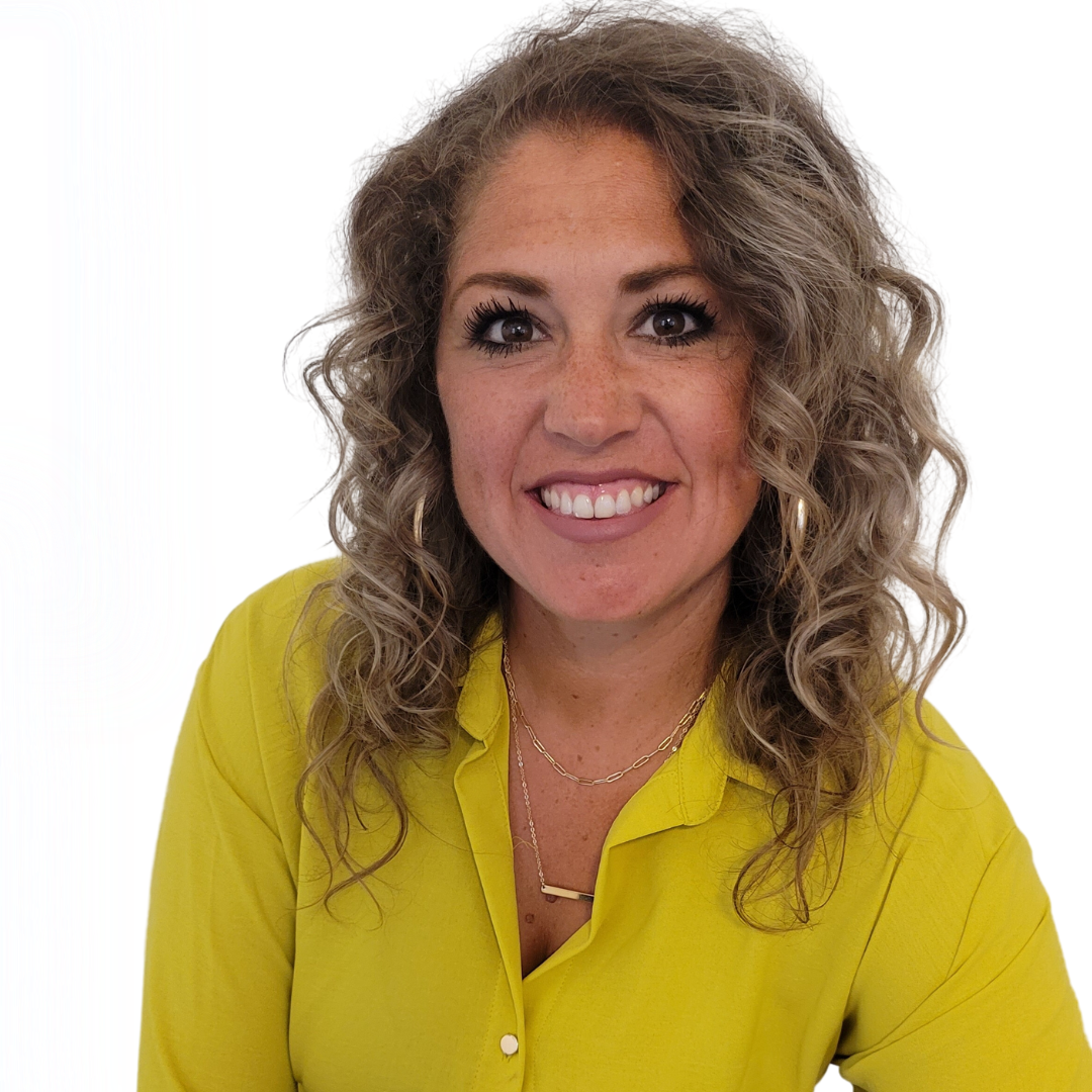 A woman with curly hair is wearing a yellow shirt and smiling