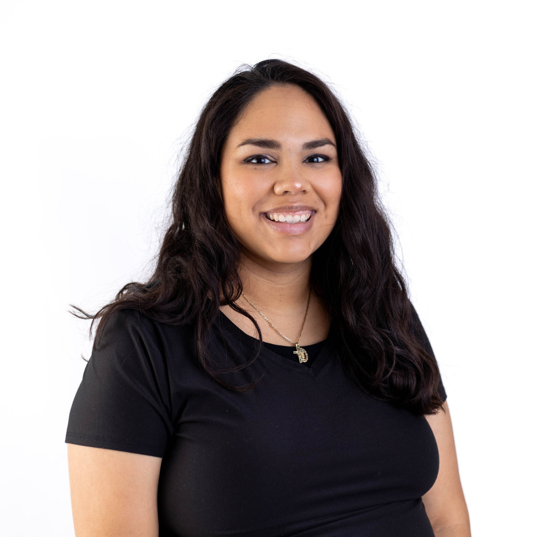a woman in a black shirt and necklace is smiling for the camera .
