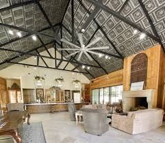 Spacious interior with vaulted ceiling, large fan, fireplace, and wood accents.