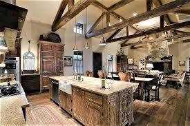 Rustic kitchen with wood beams, island, and adjacent dining and living areas.