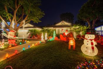 A house is decorated with Christmas lights and decorations at night.