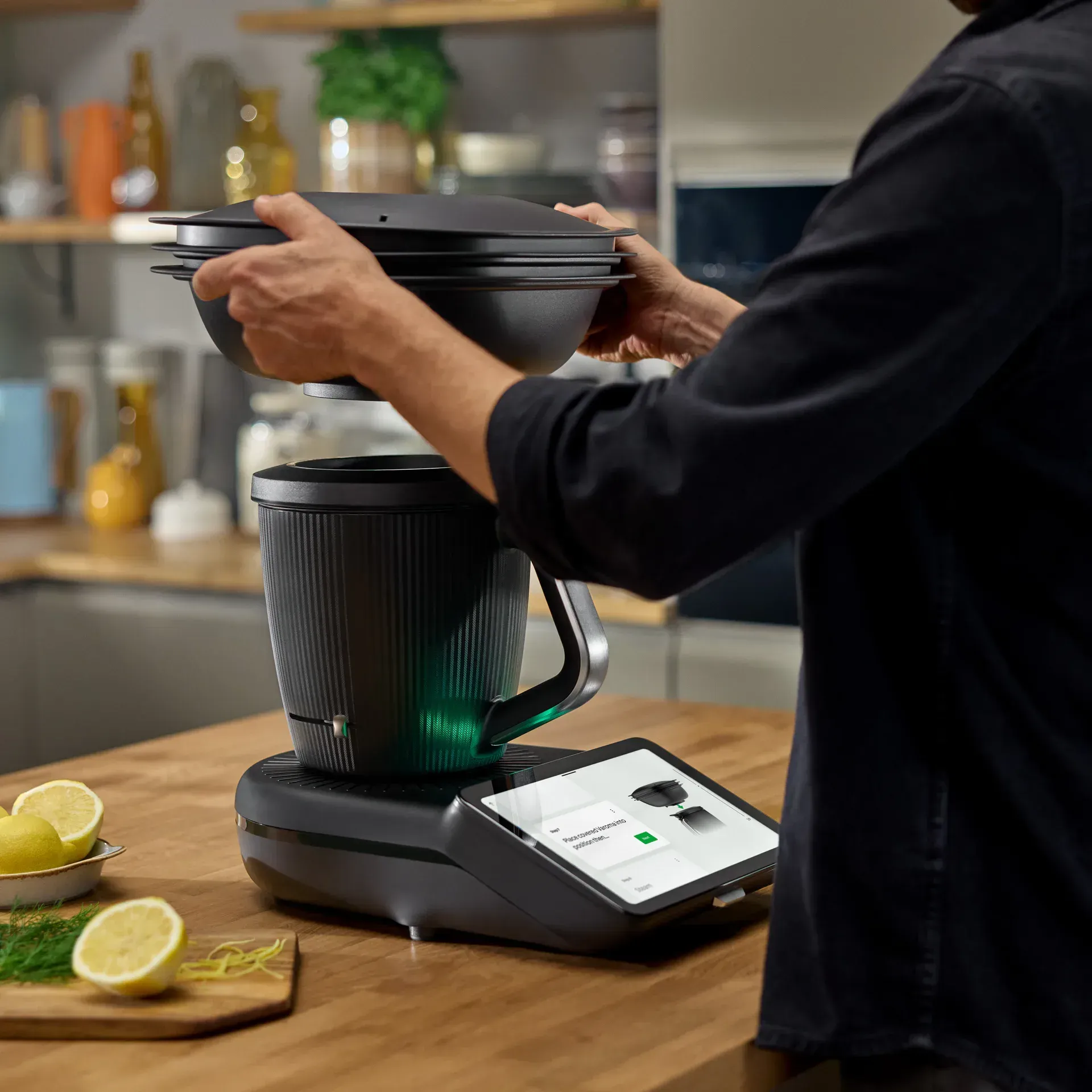 Person Placing a Black Thermomix — Clare Quintieri Thermomix Consultant in Mareeba, QLD
