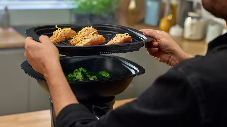 Hands Holding a Black Takeout Tray With Grilled Chicken — Clare Quintieri Thermomix Consultant in Mareeba, QLD
