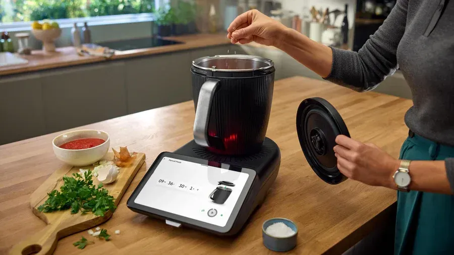 Person Adding Ingredients to a Black Cooking Pot — Clare Quintieri Thermomix Consultant in Mareeba, QLD