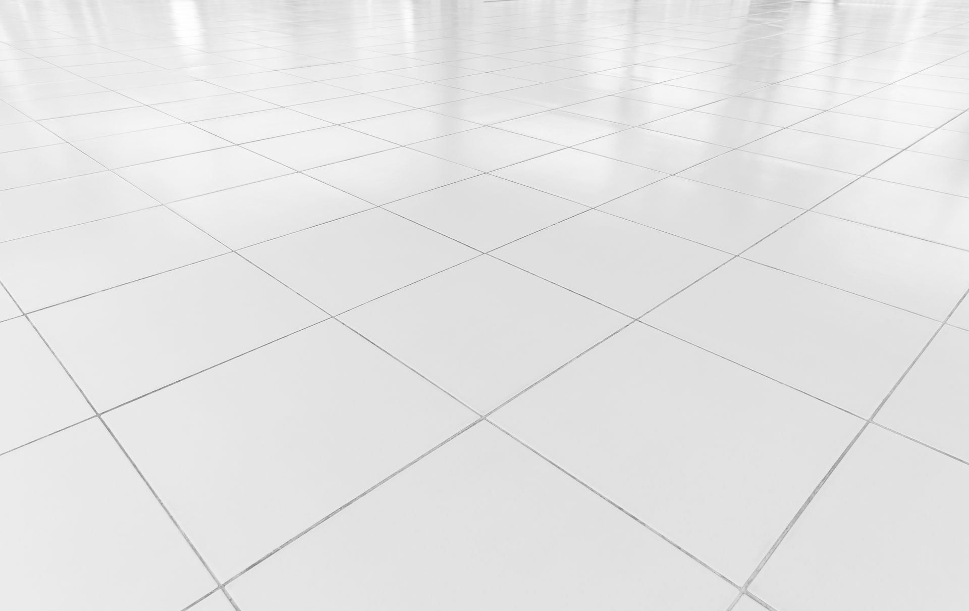 Blank white tiled floor with faint gray grid lines in a bright, empty room