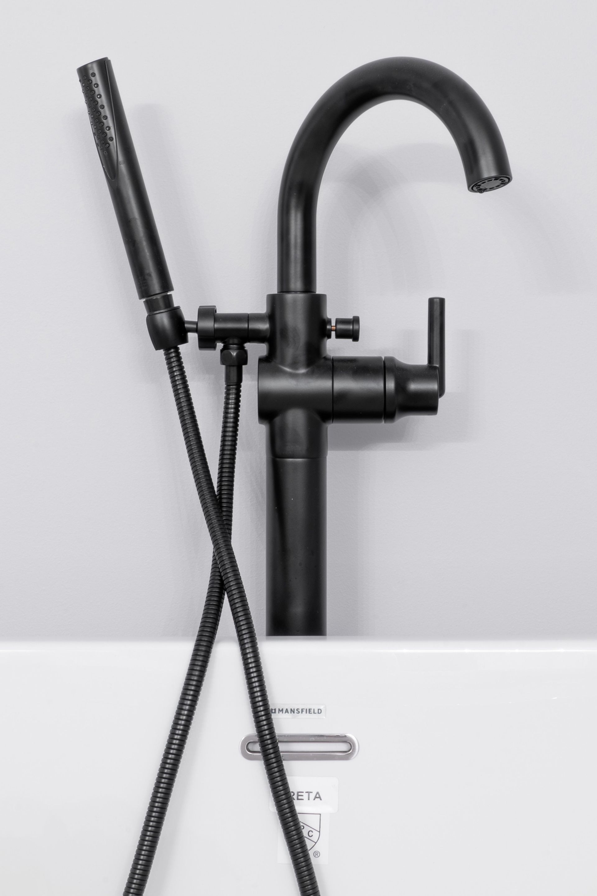Black matte faucet with handheld sprayer over a white sink in a modern bathroom