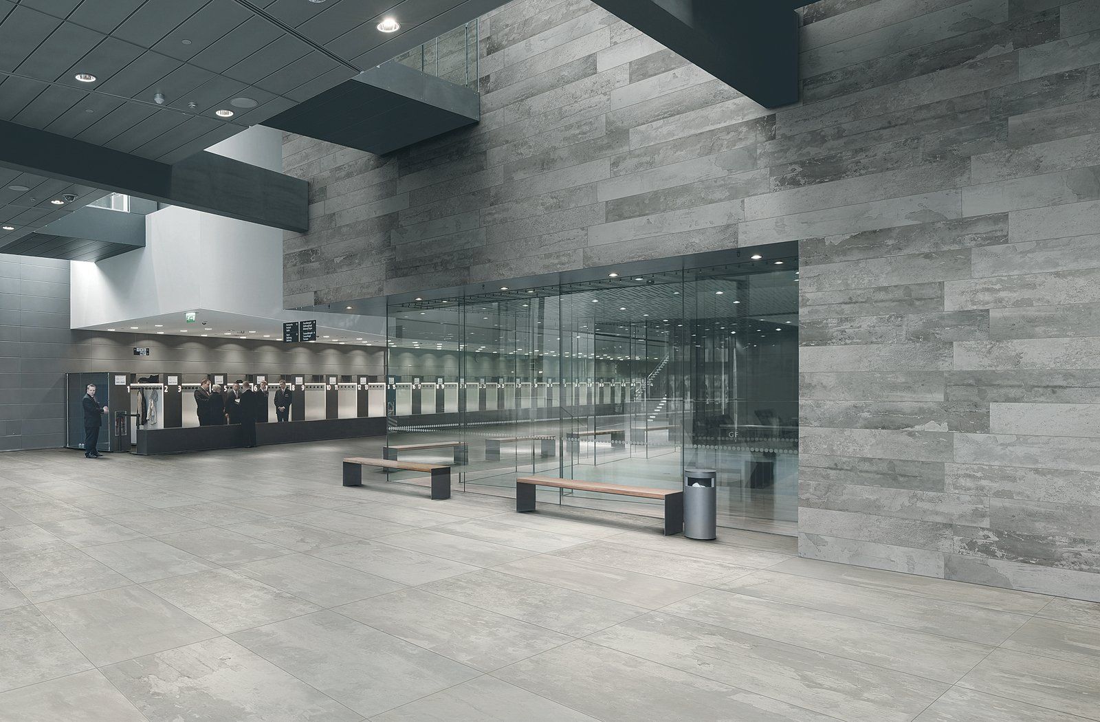 Modern airport terminal with marble floors, glass walls, and empty seating area