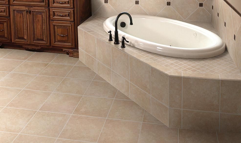 Bathroom with a white oval tub, black faucet, beige tile floor, and wooden cabinets