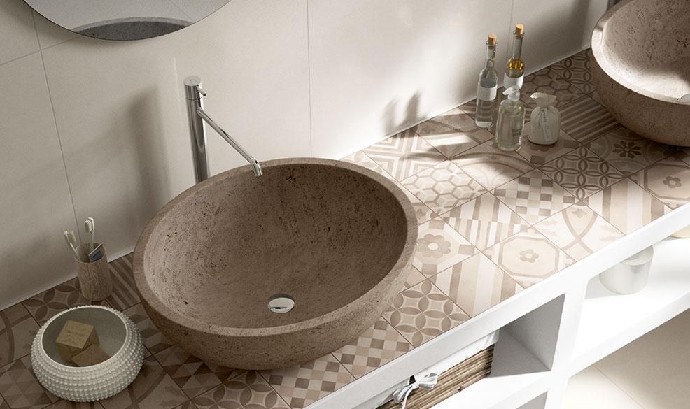Modern bathroom vanity with round stone sinks, patterned countertop, and chrome faucets
