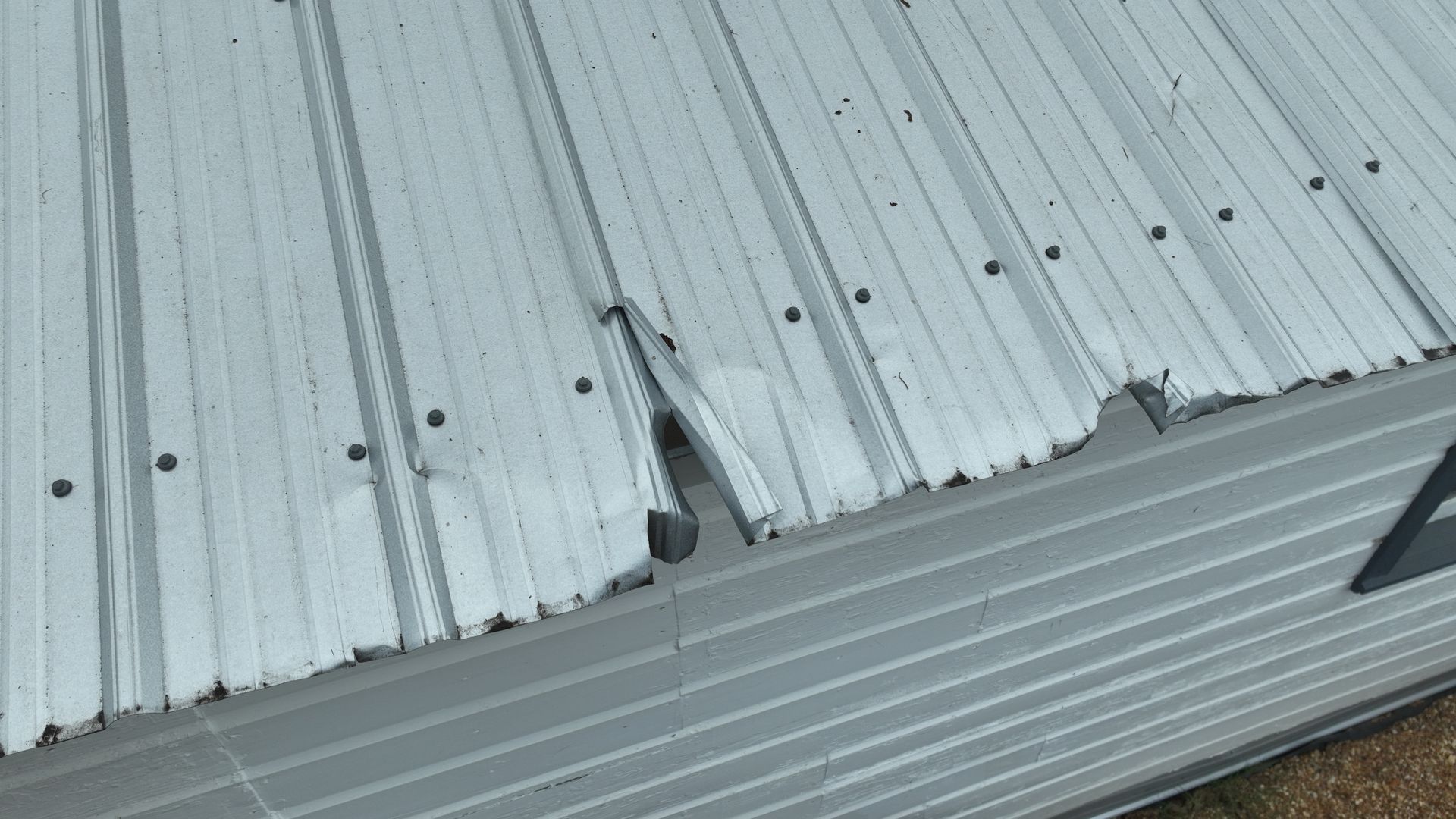 Metal roof wind damage documented during a wind mitigation inspection near Perry, FL