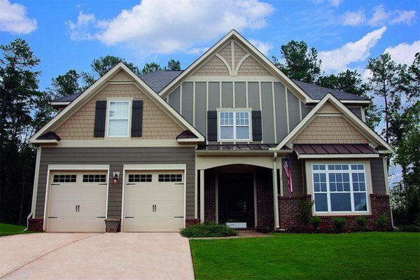 A large house with a lot of windows and garage doors
