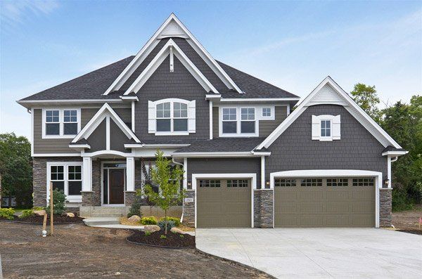 A large house with two garage doors and a driveway