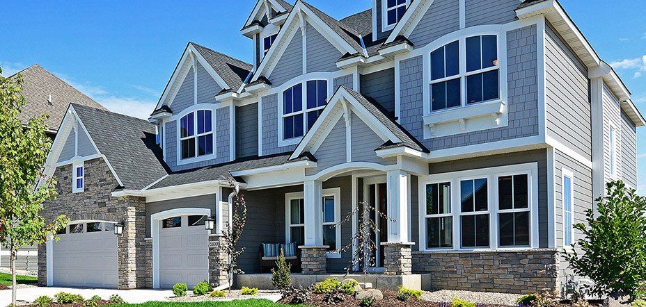A large house with a lot of windows and a gray siding