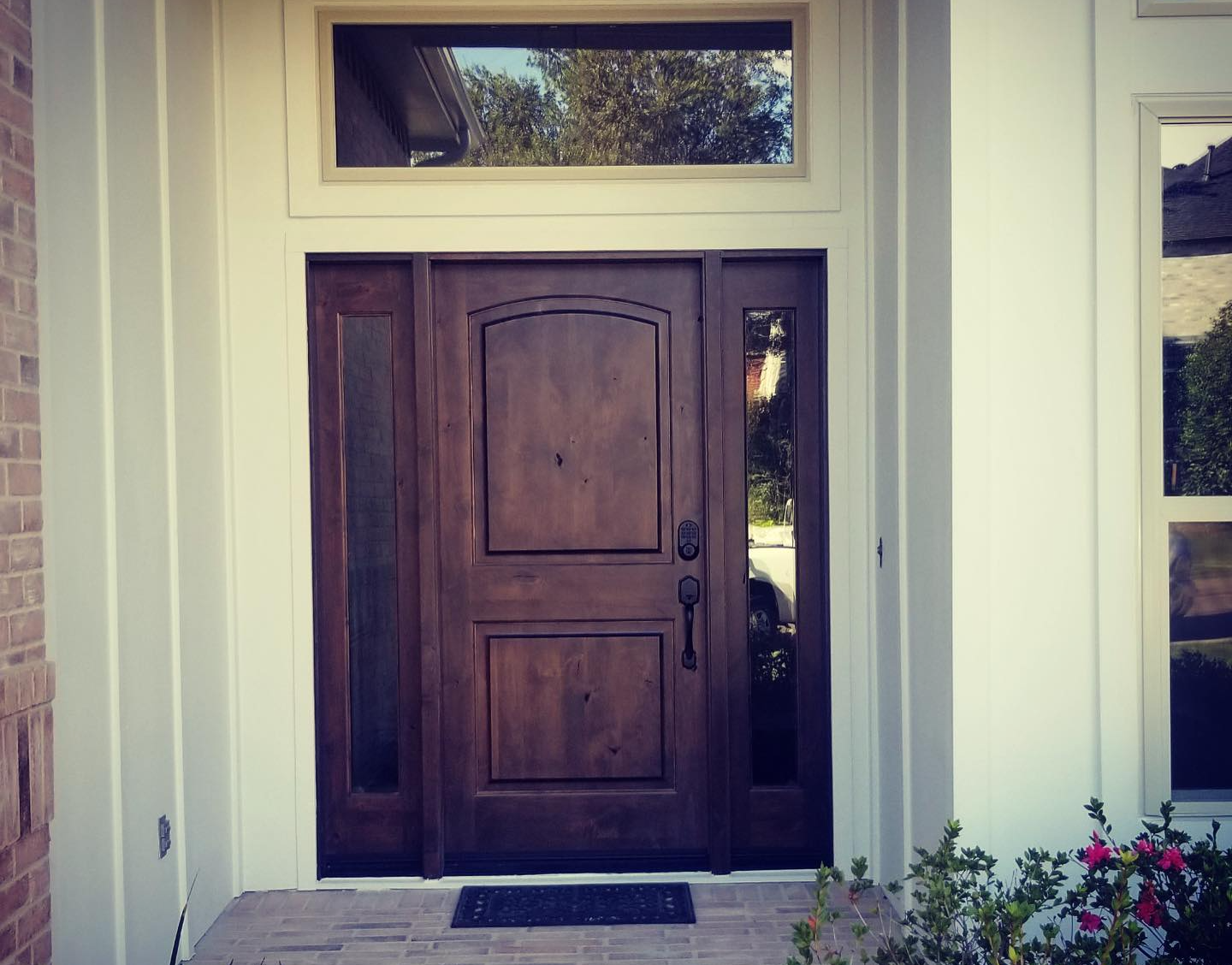 Wooden front door with sidelights and a transom window at a house entrance