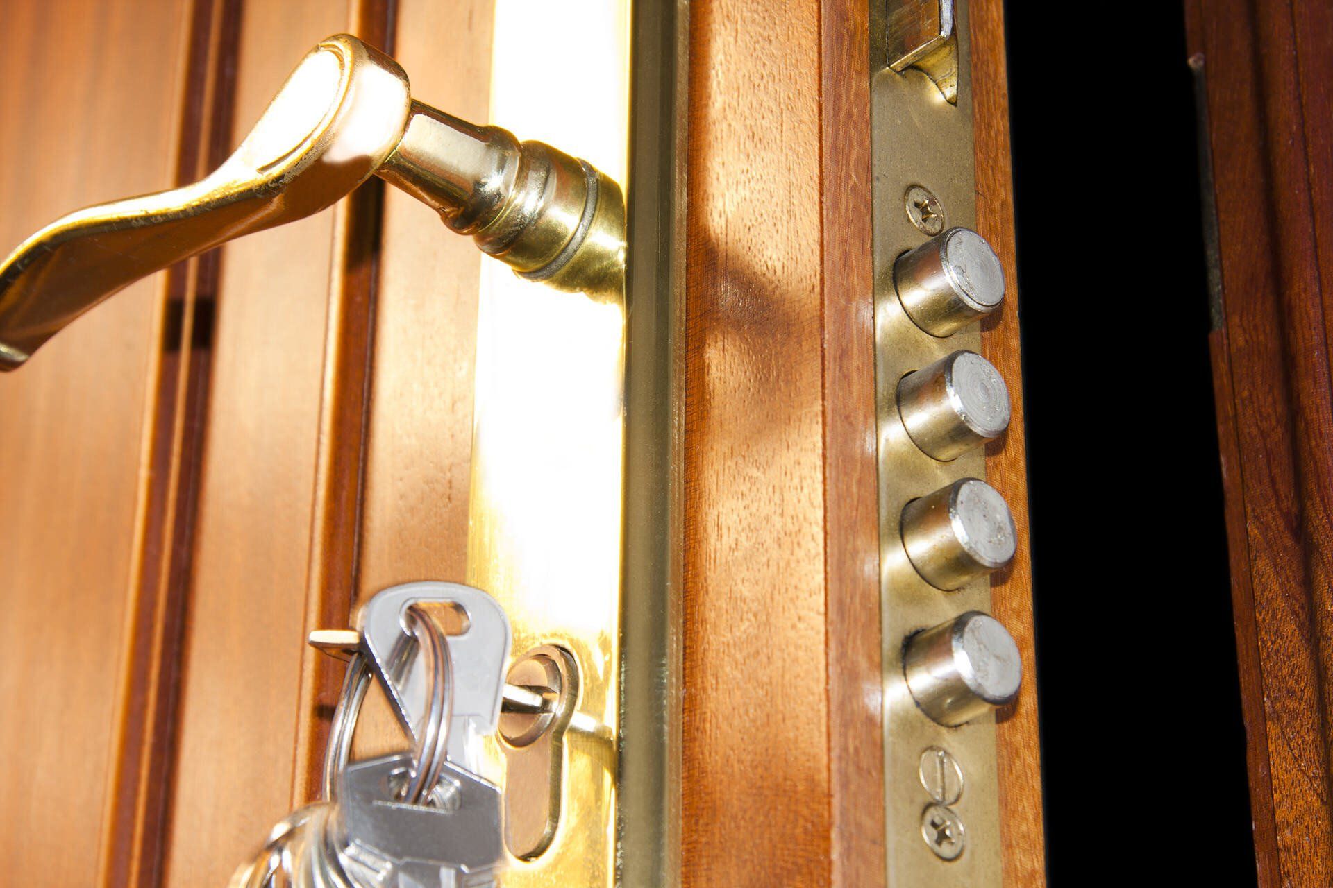 Front door with brass handle and key inserted in a silver lock, showing a security lockset.