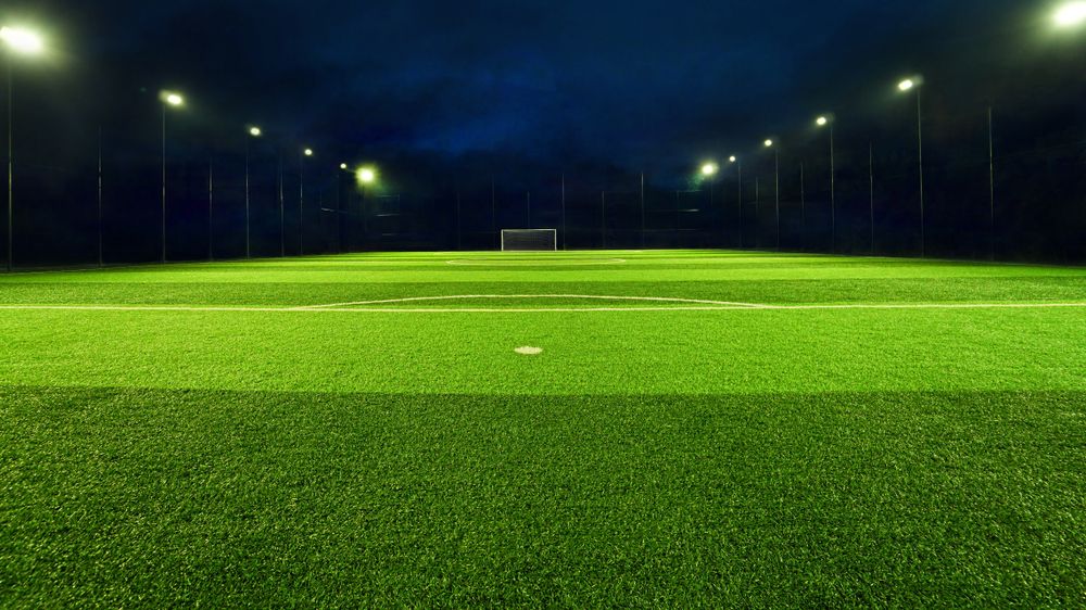 An Empty Soccer Field is Lit Up at Night — Oaks Quality Turf In Kiama, NSW