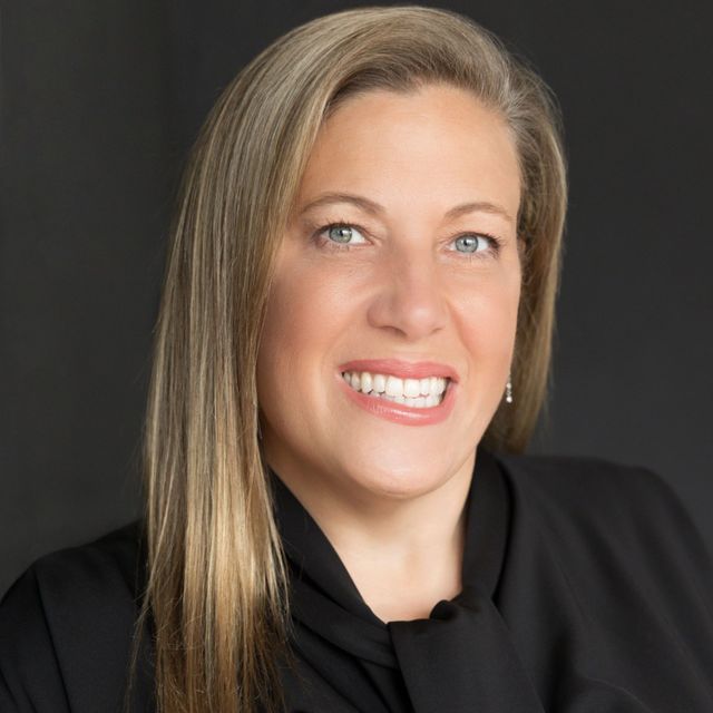 DEB CURRY Profile Picture - a woman in a black shirt and tie is smiling for the camera .