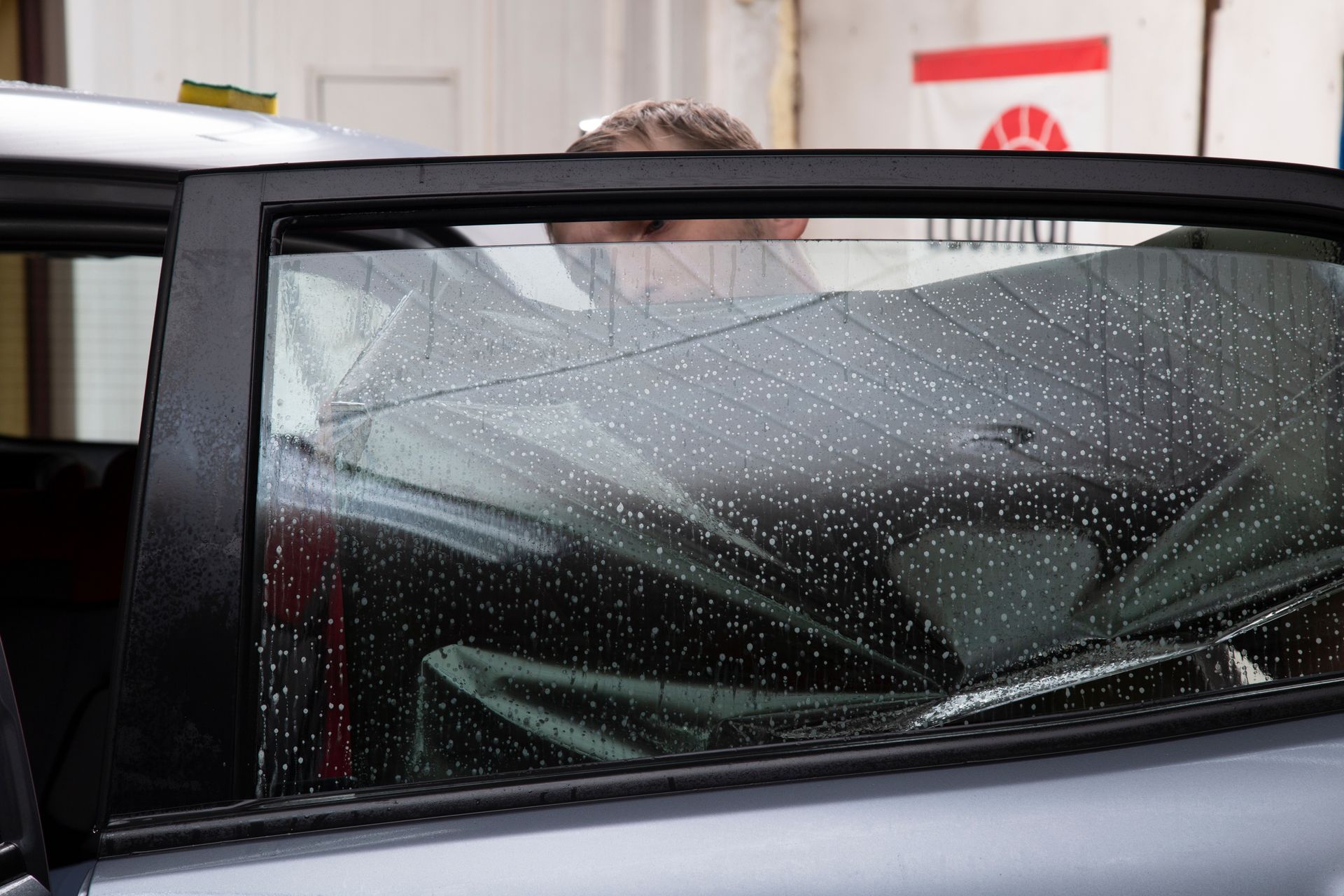Un homme regarde par la fenêtre d'une voiture.