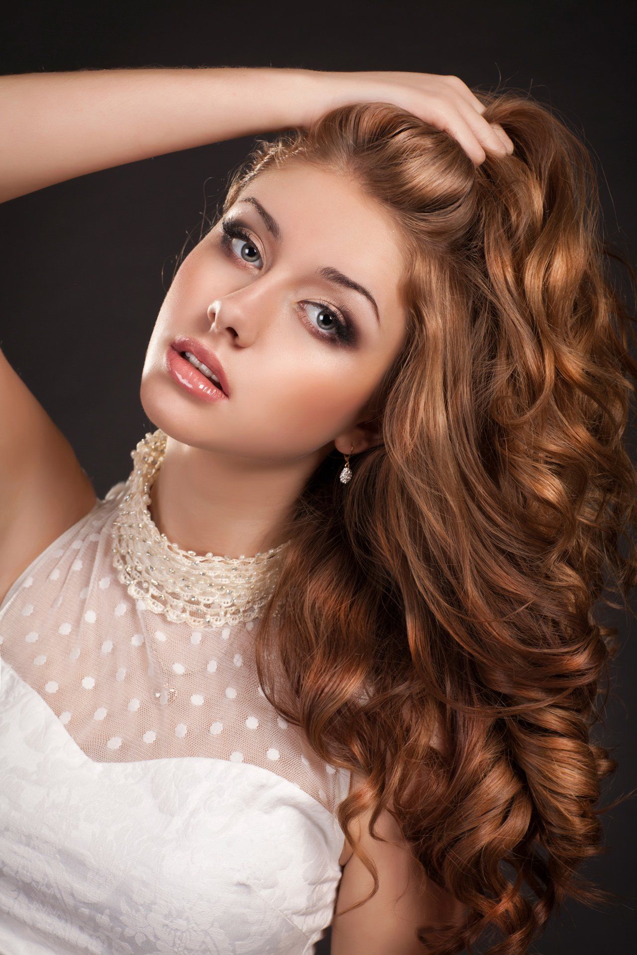 Woman Holding Her Curly Hair — Miami, FL & Sunrise, FL — Elite Designer Wigs & Hair Extensions Woman Holding Her Curly Hair — Miami, FL & Sunrise, FL — Elite Designer Wigs & Hair Extensions