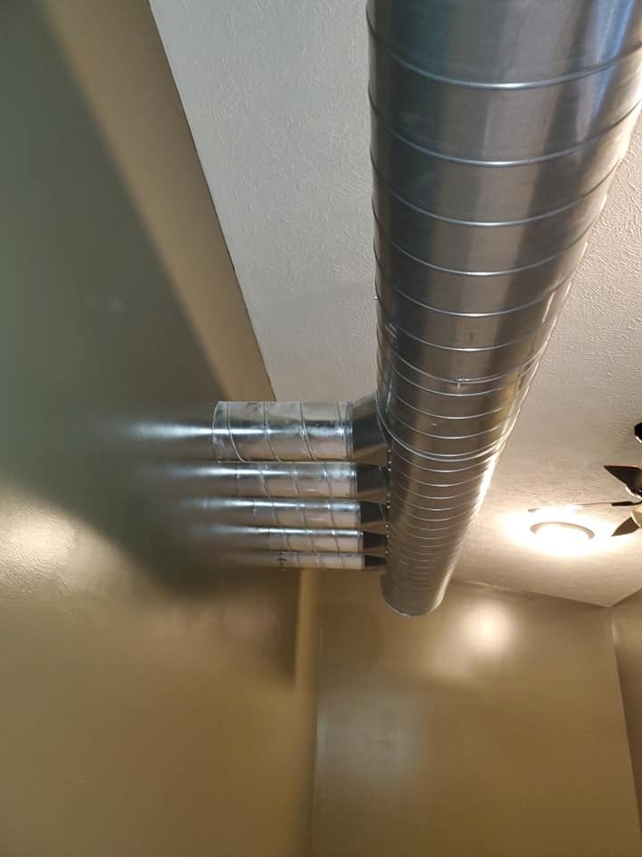 A metal pipe is hanging from the ceiling of a room.