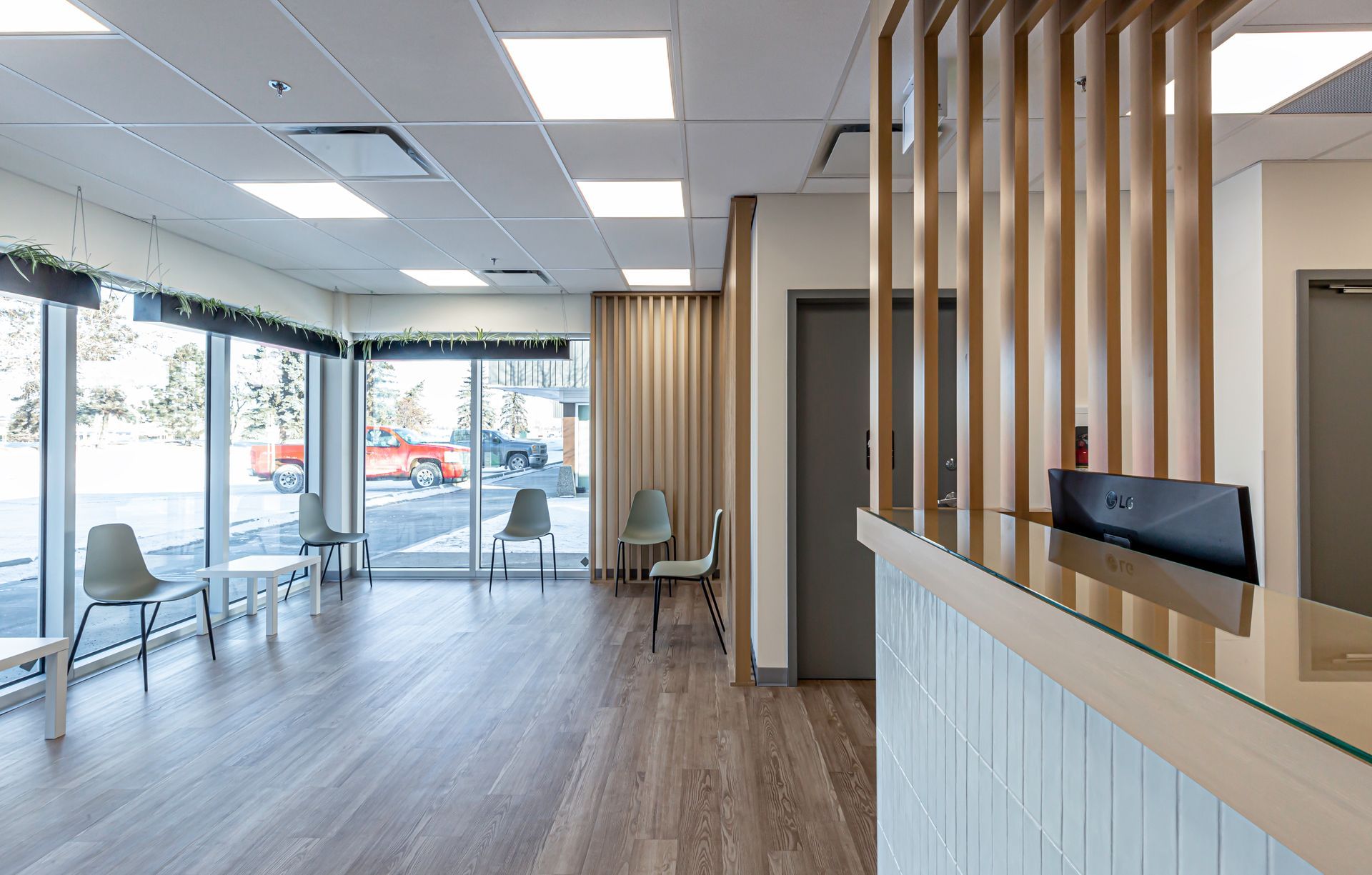 A waiting room with a reception desk and chairs in a dental office.