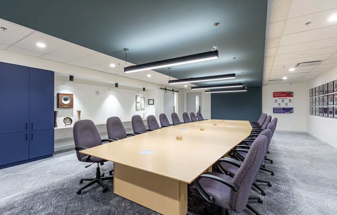 A conference room with a long table and chairs.