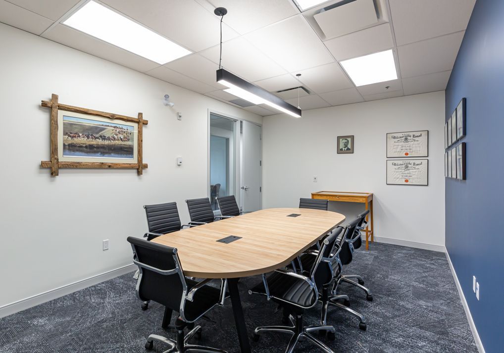 A conference room with a long table and chairs.