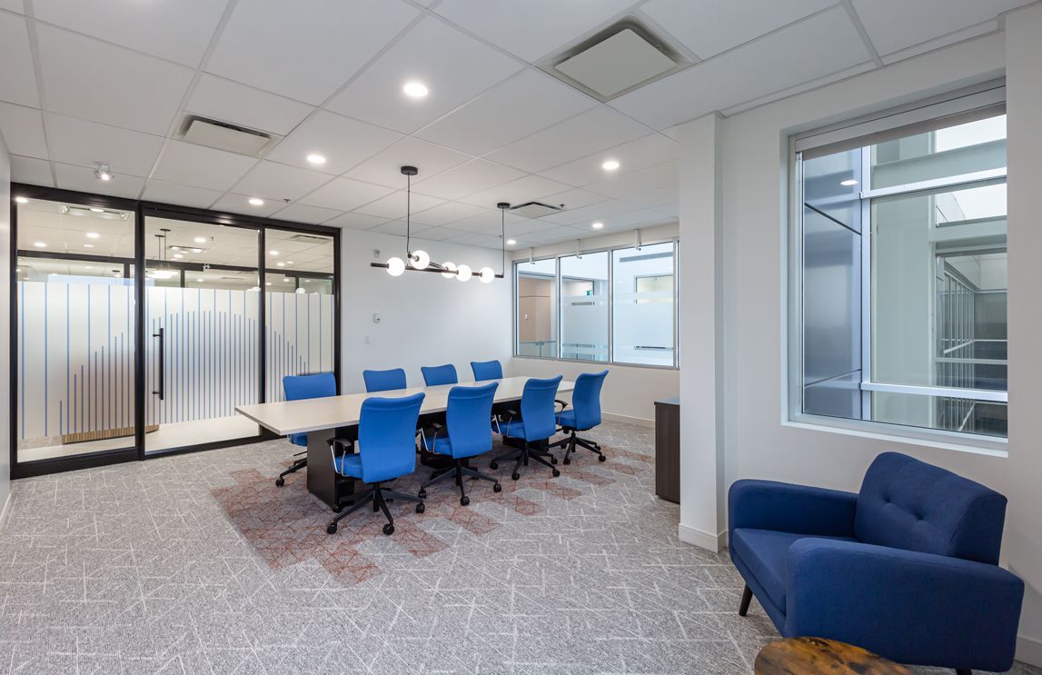 A conference room with a table and chairs and a blue chair.