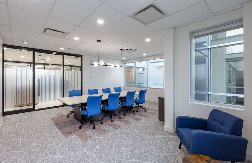A conference room with a table and chairs and a blue chair.